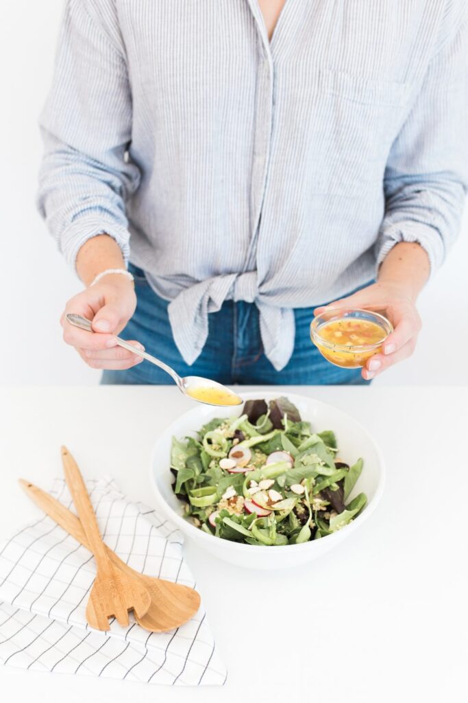 Drizzling salad dressing over salad