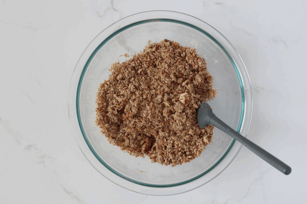 mixing pecan topping ingredients in glass bowl with small spatula