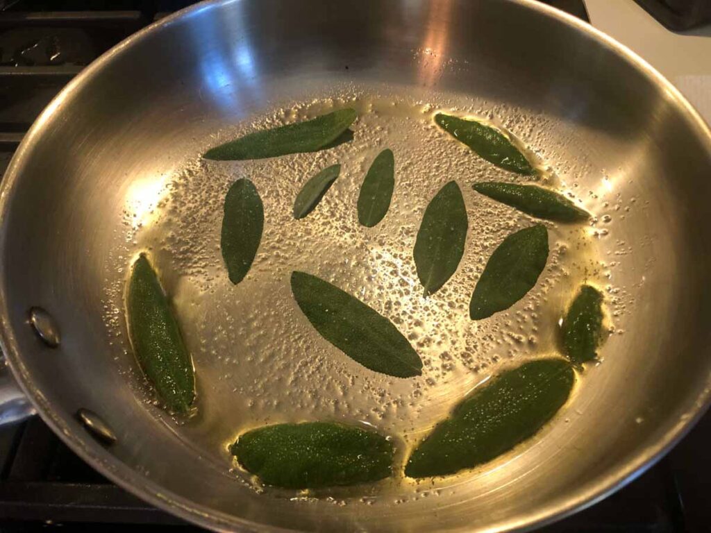 frying sage leaves in skillet with olive oil
