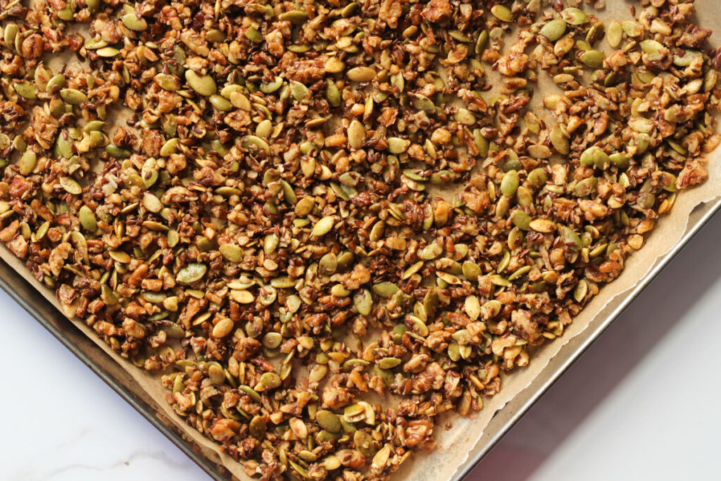 View of baked pumpkin seed granola on baking sheet from above at an angle