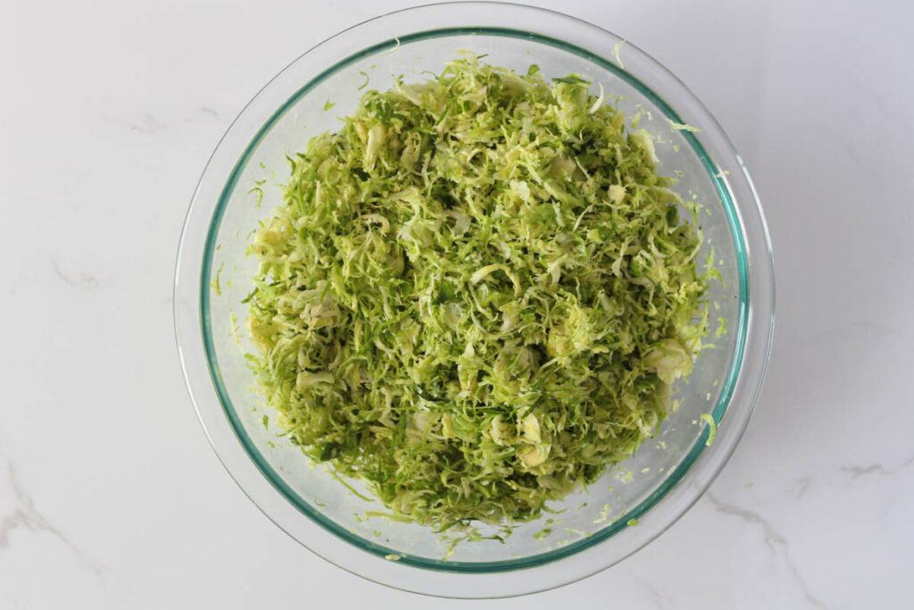 Massaged shaved Brussels sprouts in glass bowl