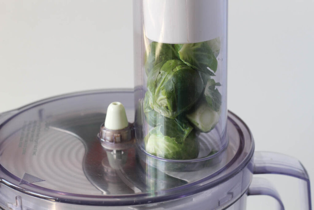 Brussels sprouts in feed tube of food processor