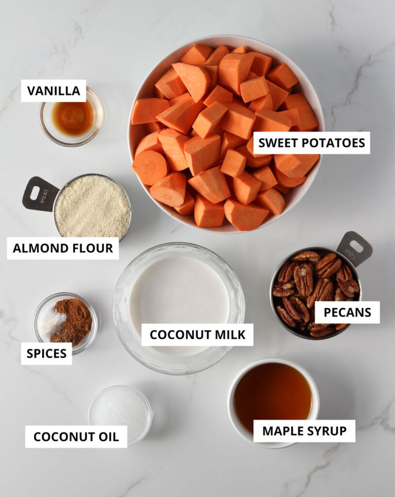 Sweet potato casserole recipe ingredients in bowls and measuring cups sitting on marble counter